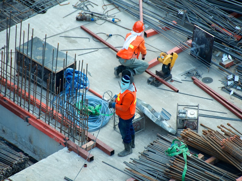 Operai edili con elmetti di sicurezza arancioni che lavorano in un cantiere